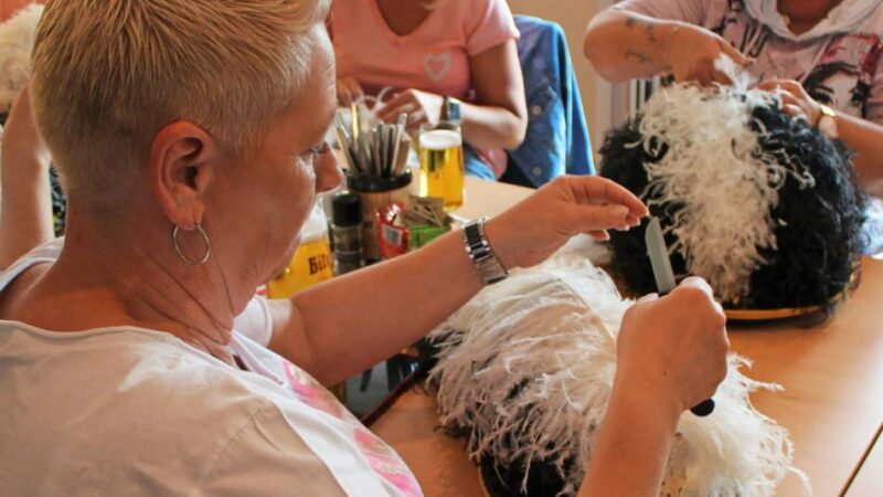 Federkräusel-Seminar zum Neusser Schützenfest: „Bei starkem Regen sieht das aus wie ein toter Dachs auf dem Kopf“