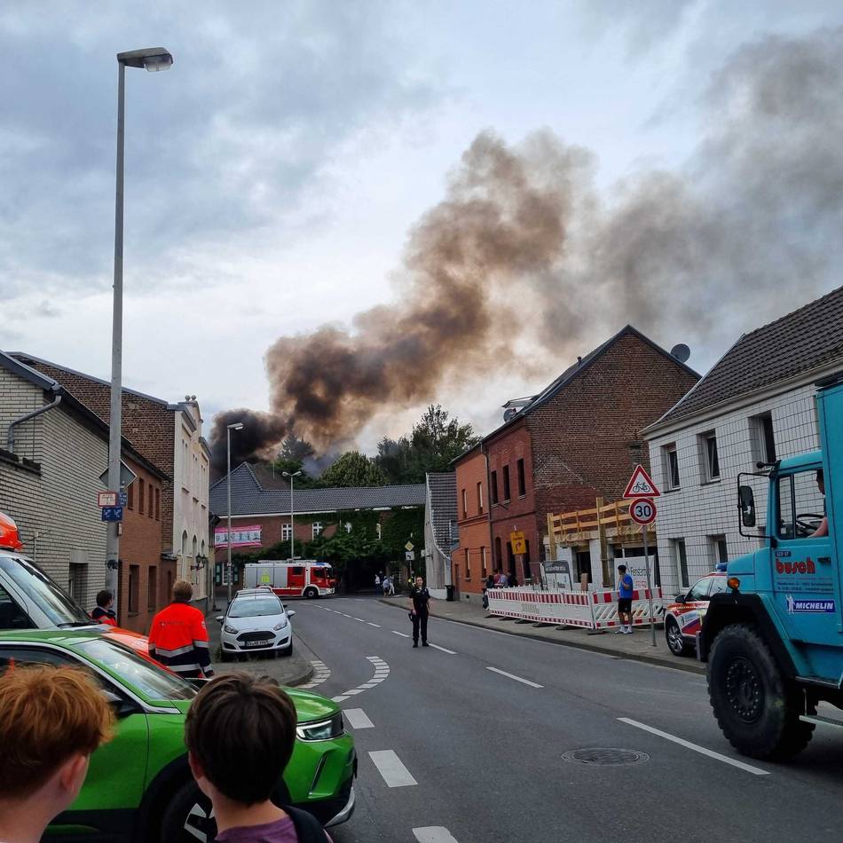 Feuerwehr im Großeinsatz: Rauchwolke über Jüchener Innenstadt – Holzlager steht in Flammen