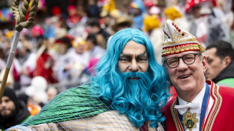 Rosenmontag vor dem Rathaus: Düsseldorfer Stadtgesellschaft feiert in Regencapes auf der Tribüne