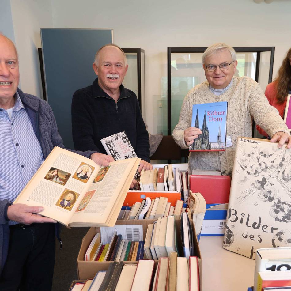 Historische Bücherbörse in Leverkusen: Besucher stöbern in alten Büchern und in eigener Familiengeschichte