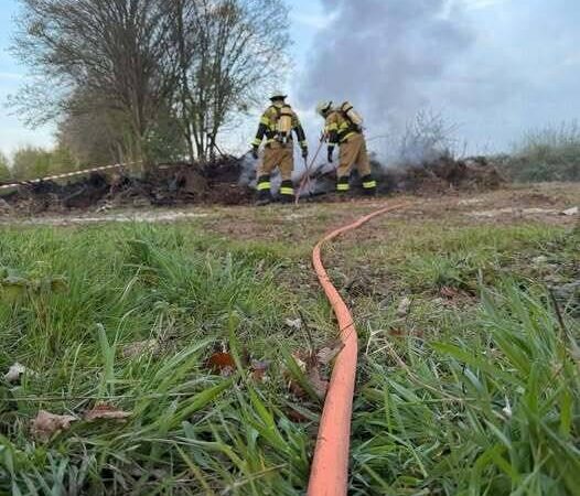Einsatz der Feuerwehr Rheinberg: Altes Holz vom Osterfeuer brennt erneut