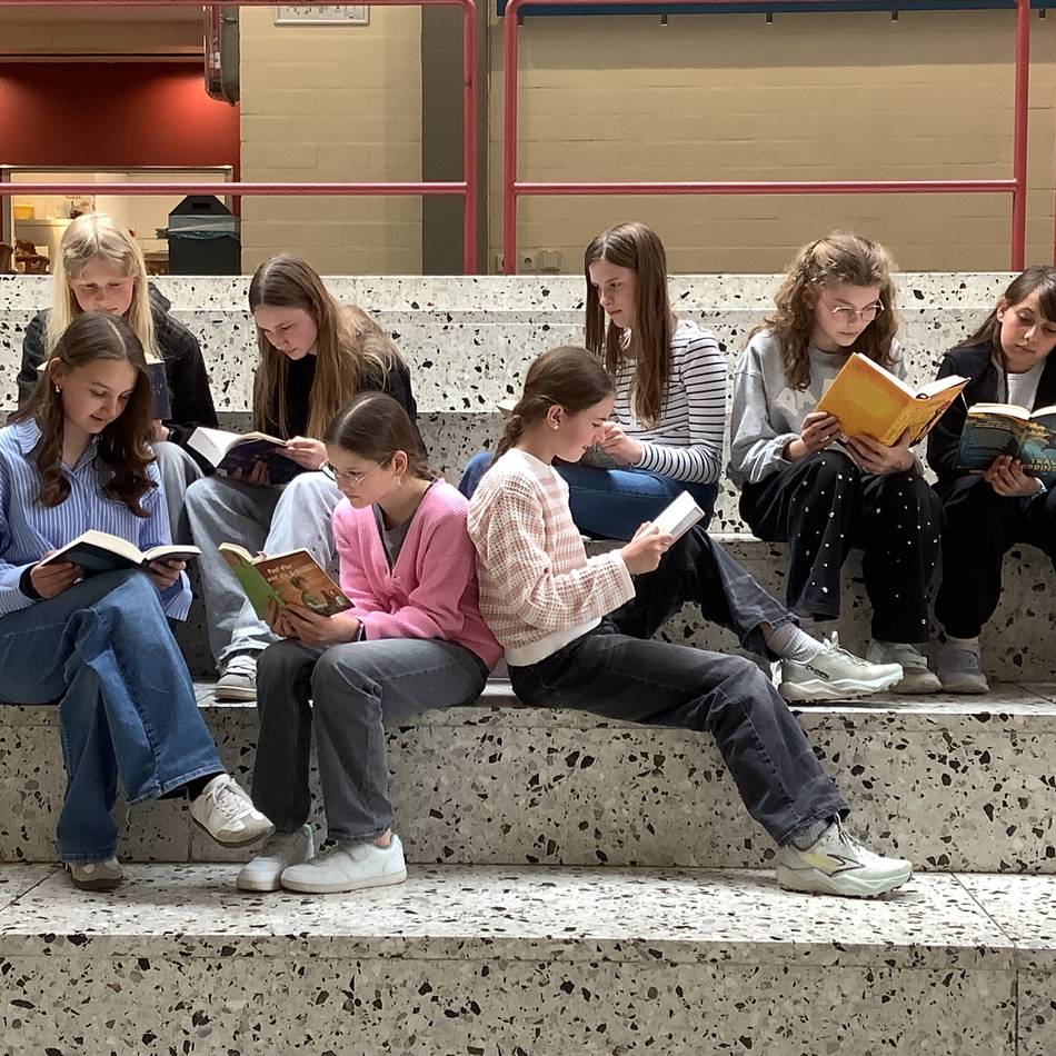 Buchhandlung in Kleve: Schülerinnen lesen im lebendigen Schaufenster