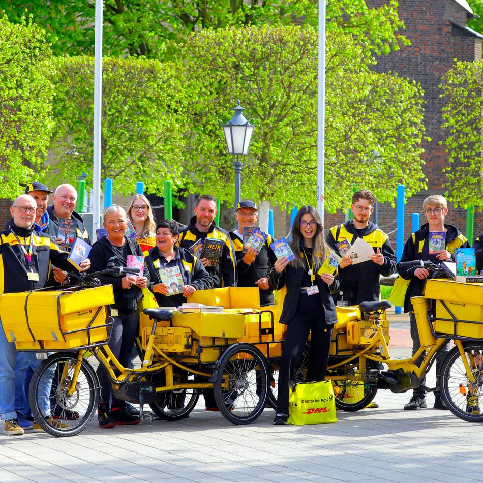 Aktion in der Innenstadt: Post-Zusteller verschenken 250 Bücher zum Welttag des Buches in Rheinberg