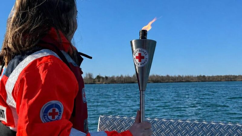 „Fiaccolata“ macht Station in Alpen und Rheinberg: Rettungshunde und Schwimmer bringen Fackel über den Rhein