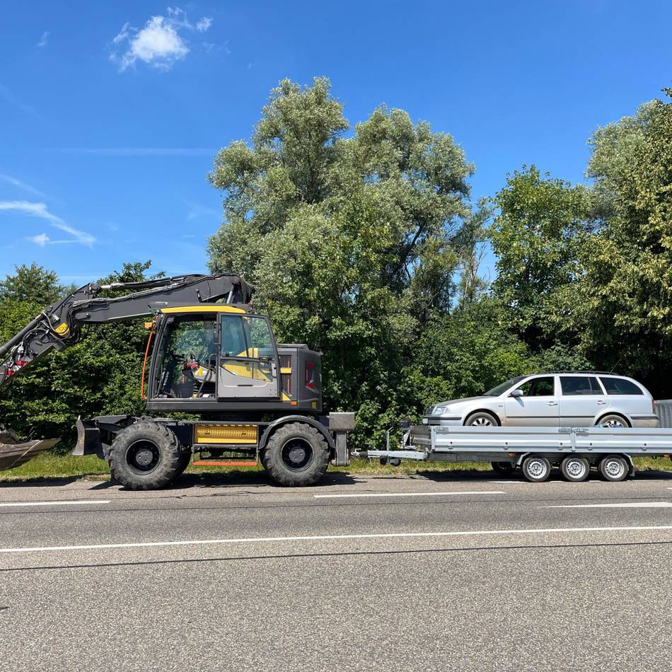 Schaufelbagger zieht Anhänger mit Auto: Polizei stoppt „ungewöhnliches Gespann“ auf der B58