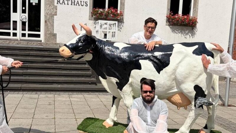 Kuriose Aktion in Grevenbroich: Warum vier Männer mit einer Kuh durch die Stadt ziehen